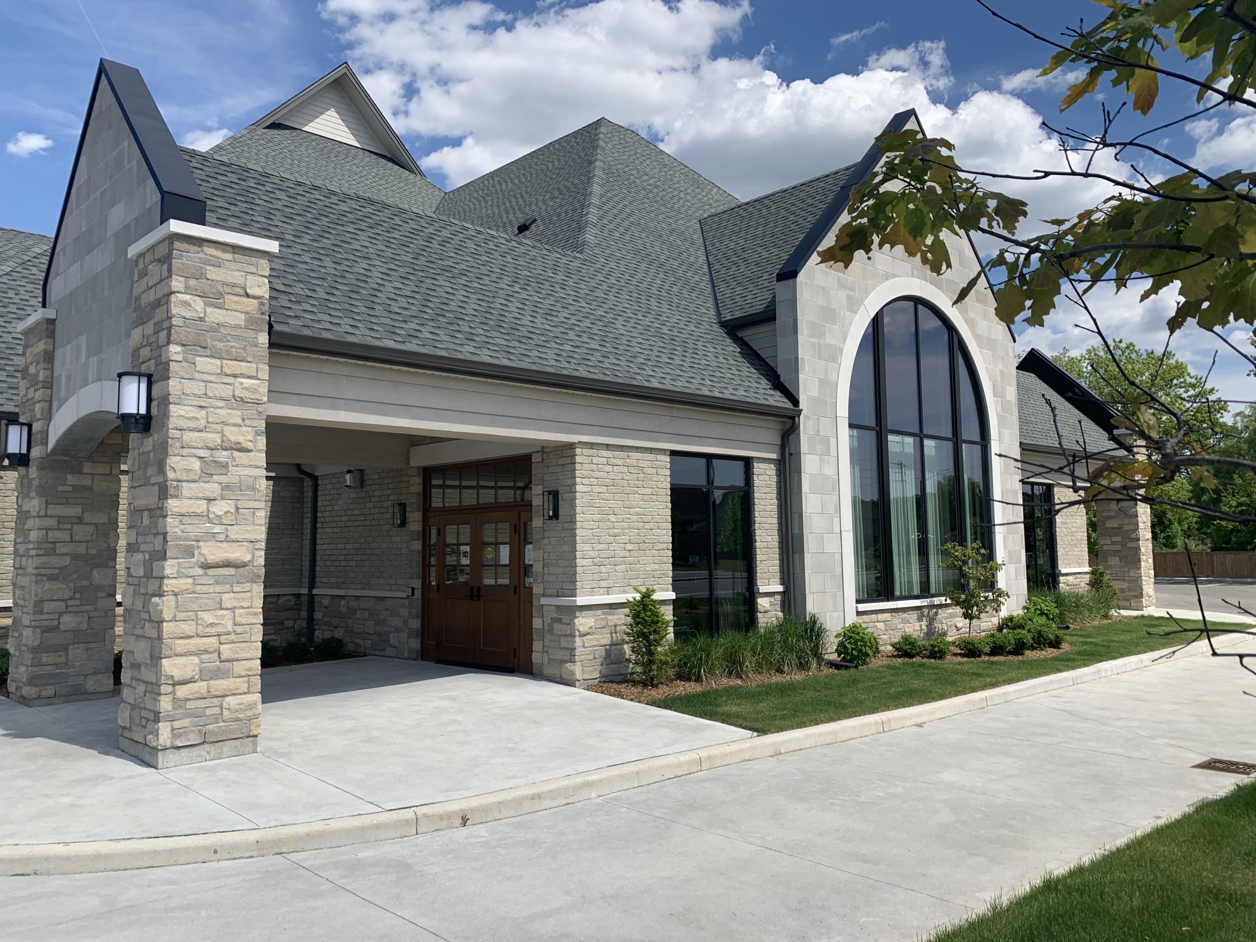 Exterior of a funeral home with brick walls and large glass window