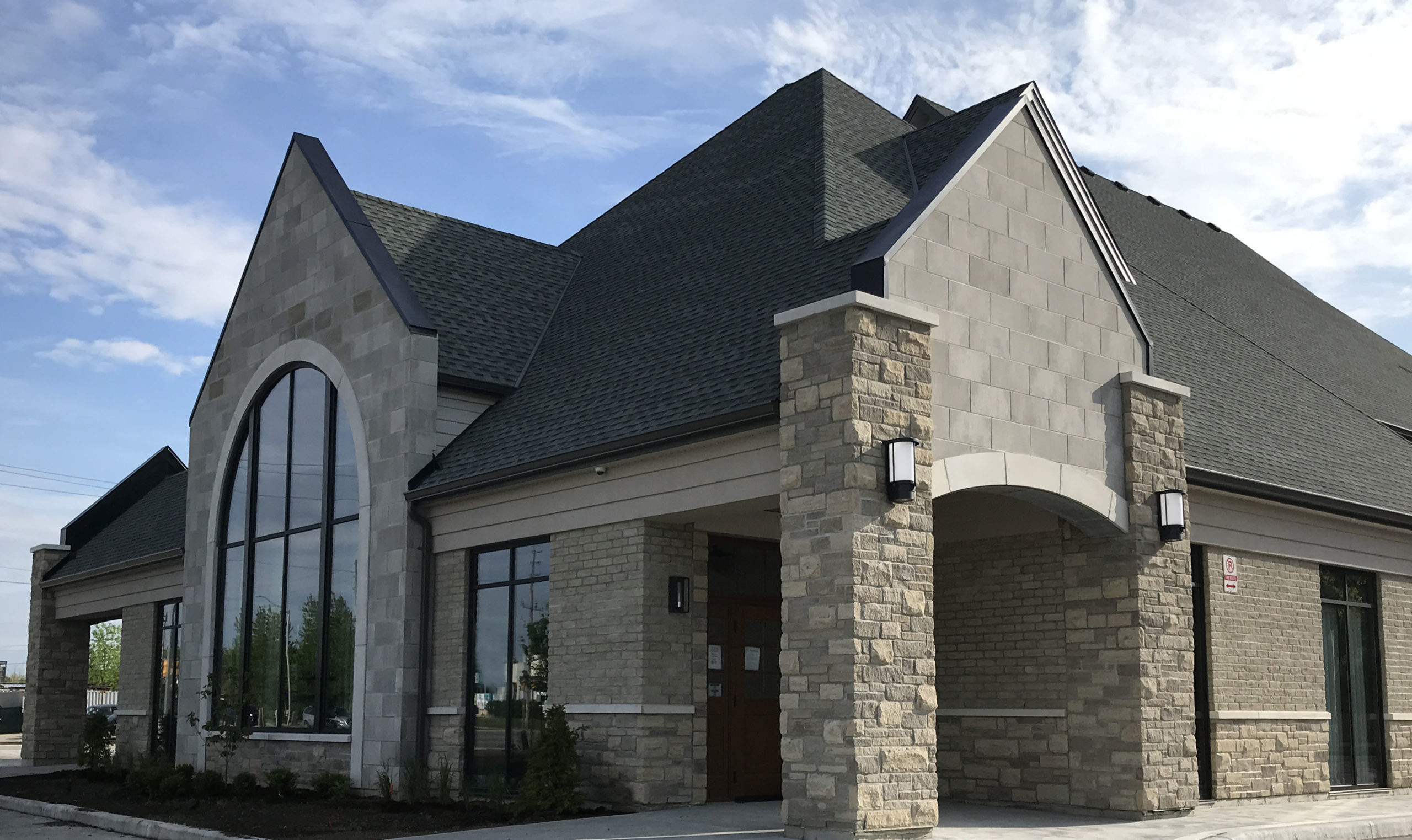 Exterior of a funeral home, with brick walls and large glass windows
